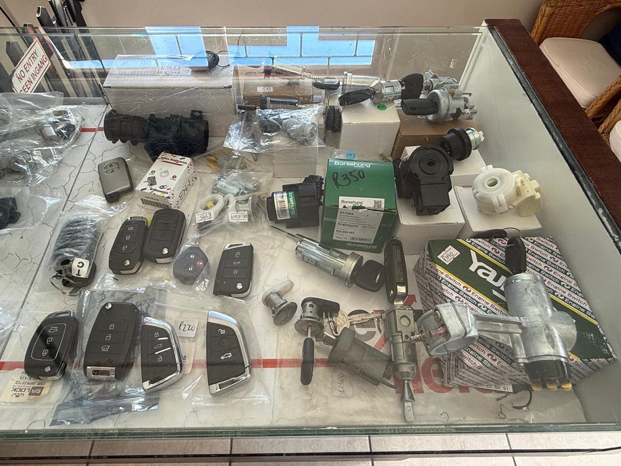 A glass display case of car key shells, remotes and ignition barrels