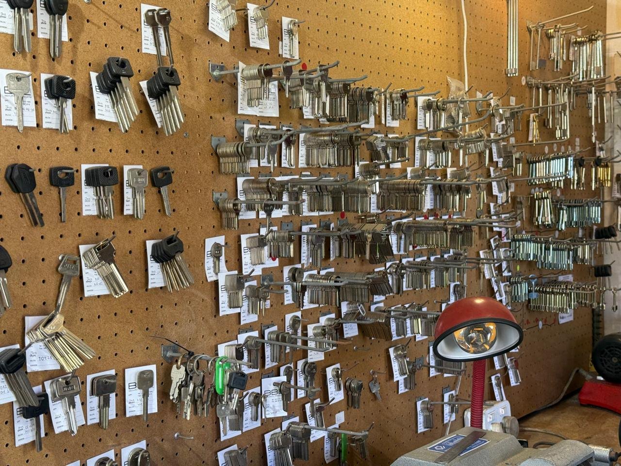 Hundreds of key blanks on the pegboard wall behind the key cutting machine at A & M Locksmith, Kleinmond
