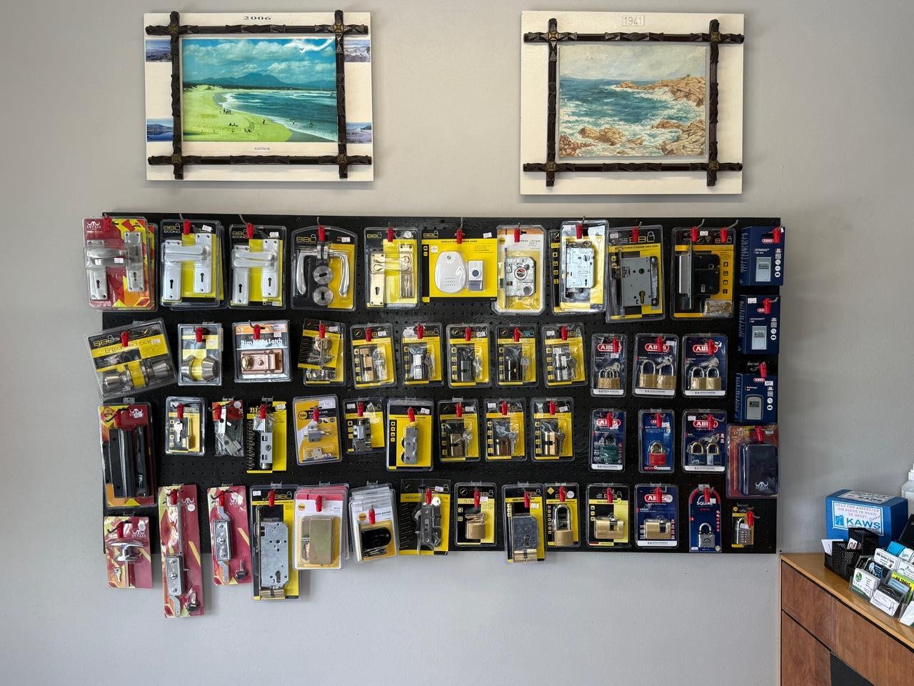 Handles, locks and padlocks on a black pegboard